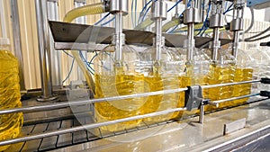 Industrial equipment filling sunflower oil in to the bottles. Factory production line. 4K.