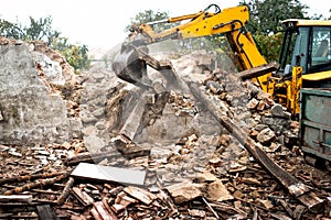 industrial excavator and bulldozer loading demolition concrete walls