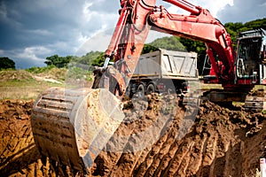 Industrial excavator digging a hole and loading earth