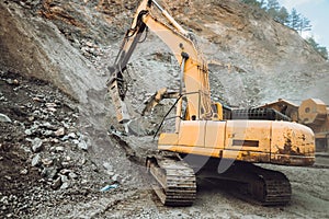 industrial excavator digging a hole and loading ore in a dumper truck at a quarry