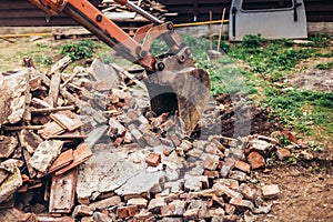 Industrial excavator using scoop for demolishing ruins