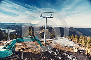 Industrial excavator working in the mountains on building slopes in ski area