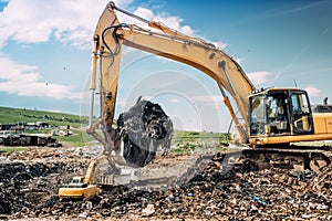 Industrial excavators and heavy duty machinery working on garbage dump site.