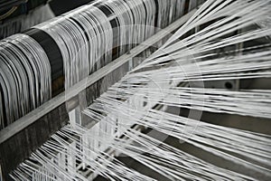 Industrial fabric production line. Weaving looms at a textile factory photo