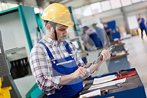 Industrial factory employee working in metal manufacturing industry