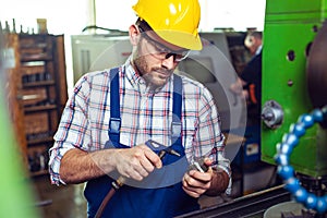 Industrial factory employee working in metal manufacturing industry.