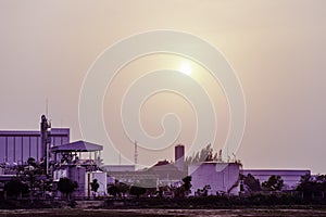 Industrial factory plant with sunset sky clouds