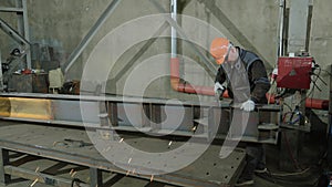 In the industrial factory the welder with safety equipment weld the metal in front of the camera sparks flying