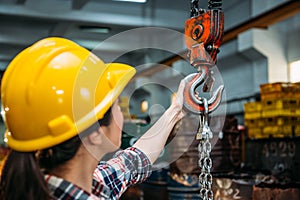 Industrial factory woman holding chain crane