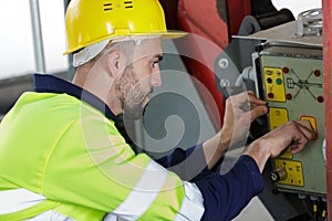 Industrial factory worker operates machine