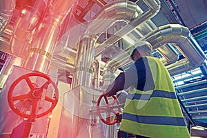 Industrial factory worker turning red wheel valve