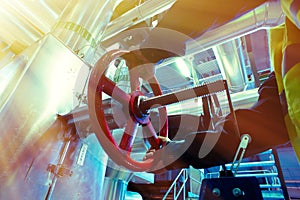 Industrial factory worker turning red wheel of valve