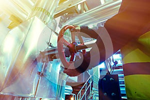 Industrial factory worker turning red wheel of valve