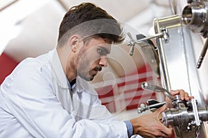 Industrial factory worker turning valve