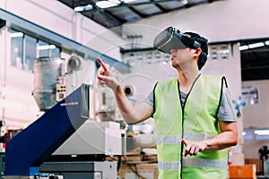 Industrial factory worker wearing VR goggle touching in virtual reality world inside factory