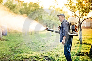 Industrial farm worker doing pest control using insecticide photo