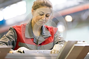 Industrial female worker on manufacture workshop background