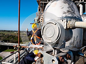 Industrial field instrumentation on metal pipes with workers