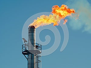 Industrial Flare Stack Burning Gas Against Sky