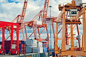 Industrial harbor, gantry cranes and container ship. Red and orange industrial cranes in port of Santa Cruz de Tenerife. photo