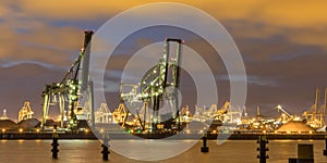 Industrial harbor landscape with two loading cranes at night