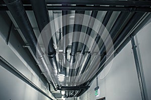 Industrial heating pipes under celling or another household communications pipelines in modern building