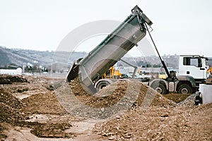 Industrial heavy duty dumper truck unloading gravel for leveling