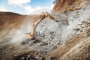 Industrial heavy duty excavator moving gravel on highway construction site