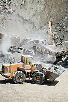 Industrial heavy duty large wheel loader moving gravel on highway construction site