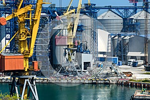 Industrial infrastructure of seaport, sea, cranes and dry cargo ship, grain silo, bulk carrier vessel and grain storage elevators