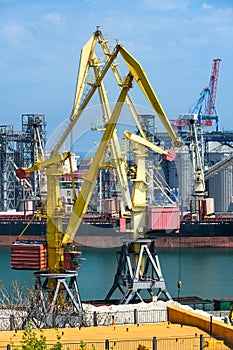 Industrial infrastructure of seaport, sea, cranes and dry cargo ship, grain silo, bulk carrier vessel and grain storage elevators