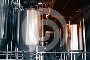 Industrial interior of modern craft brewery with chrome cylindrical metal beer tanks