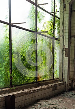 Industrial interior at the old electronic devices factory with big windows and empty floor.