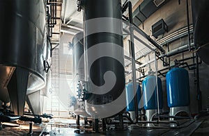 Industrial interior of water factory production. Large steel tanks for filtering and potable water treatment. Industry