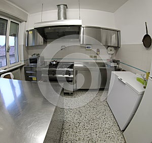 Industrial kitchen with stainless steel stove and large extracto photo