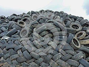 Industrial landfill for the processing of waste tires and rubber tyres. Pile of old tires and wheels for rubber