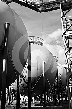 Industrial landscape bottom up view on several spherical gasholders tanks with lightning protection and safety valve on