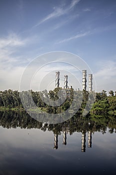 Industrial landscape of a factory situated beside a contaminated river with beautiful sky captured during sunset