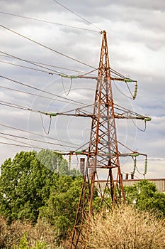 Industrial landscape. Old power transmission towers on a cloudy sky background