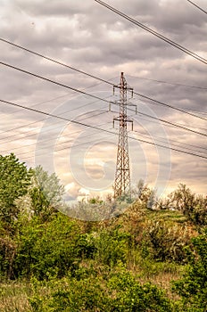 Industrial landscape. Old power transmission towers on a cloudy sky background