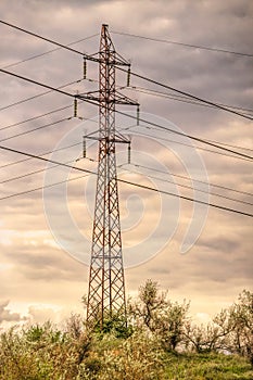Industrial landscape. Old power transmission towers on a cloudy sky background