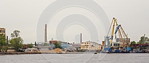 Industrial landscape with port and cargo cranes on river, shipping, trade and international logistic