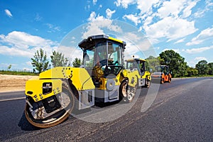 Industrial landscape with rollers that rolls a new asphalt in the roadway. Repair, complicated transport movement