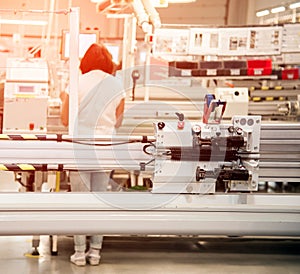 Industrial landscape with a worker behind a machine tool, which makes part of wiring for cars at a modern plant in a production