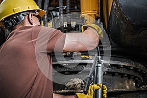 Industrial Machine Technician Pumping In the Grease