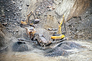 Industrial machinery and heavy duty excavators working at rock quarry