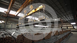 Industrial magnet placing steel bars inside the warehouse medium shot