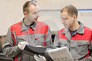 Industrial manufacturing workers deliberating in factory workshop