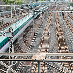 Industrial or mass transit background featuring detail of electrical railroad with local suburban train