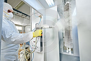 Industrial metal coating. Man in protective suit, wearing a gas